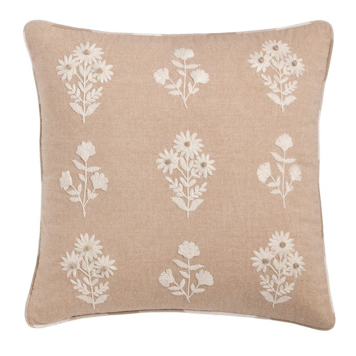 Beige pillow with white floral patterns on a beige background