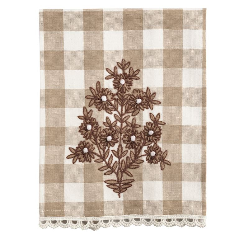 Checkered tea towel  with floral embroidery and lace trim on a white background