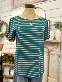 Mannequin wearing a green and beige striped shirt with a star necklace in a store setting.