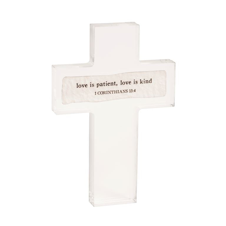 White cross with 'love is patient, love is kind' text on a white background
