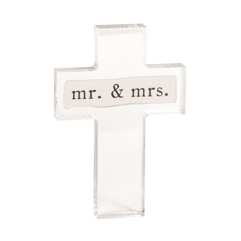 Clear glass cross-shaped object with 'mr. & mrs.' text on a white background