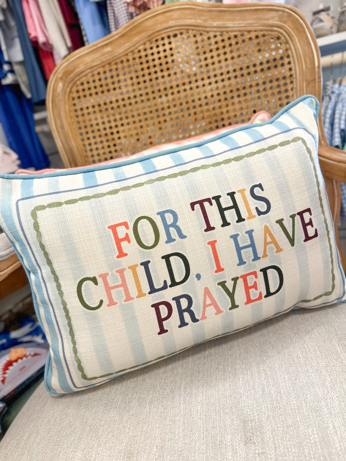 Decorative pillow with colorful text on a chair in a store setting