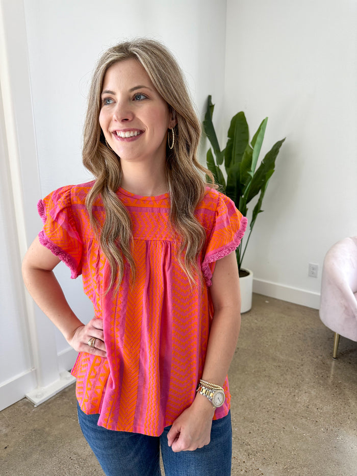 pink and orange embroidered top with flutter sleeves