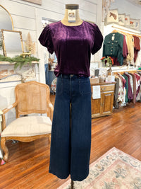 Mannequin wearing a purple top and blue jeans in a store setting