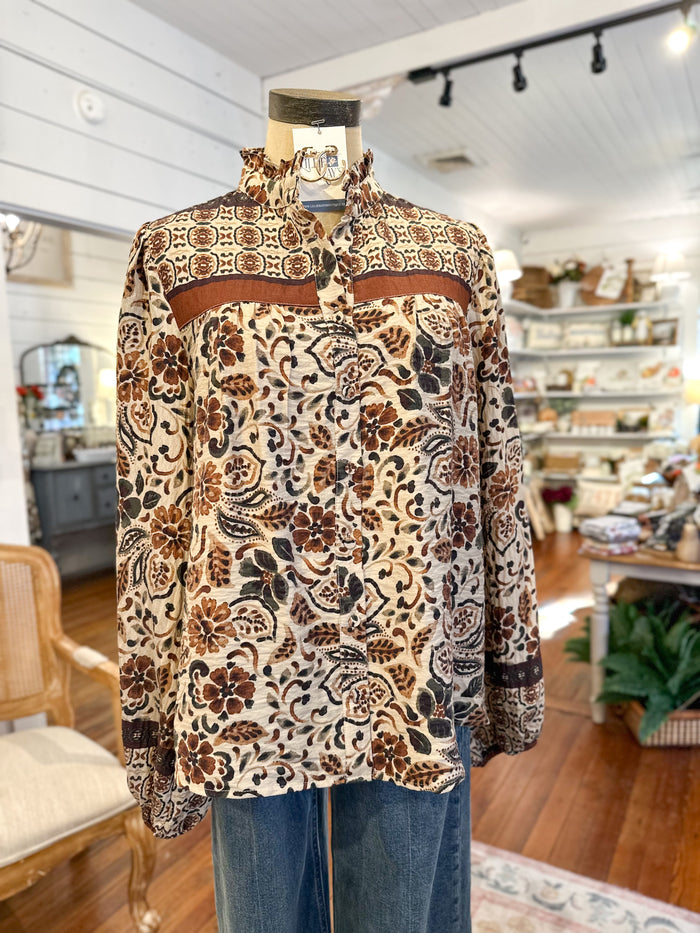 Mannequin wearing a patterned blouse in a store setting