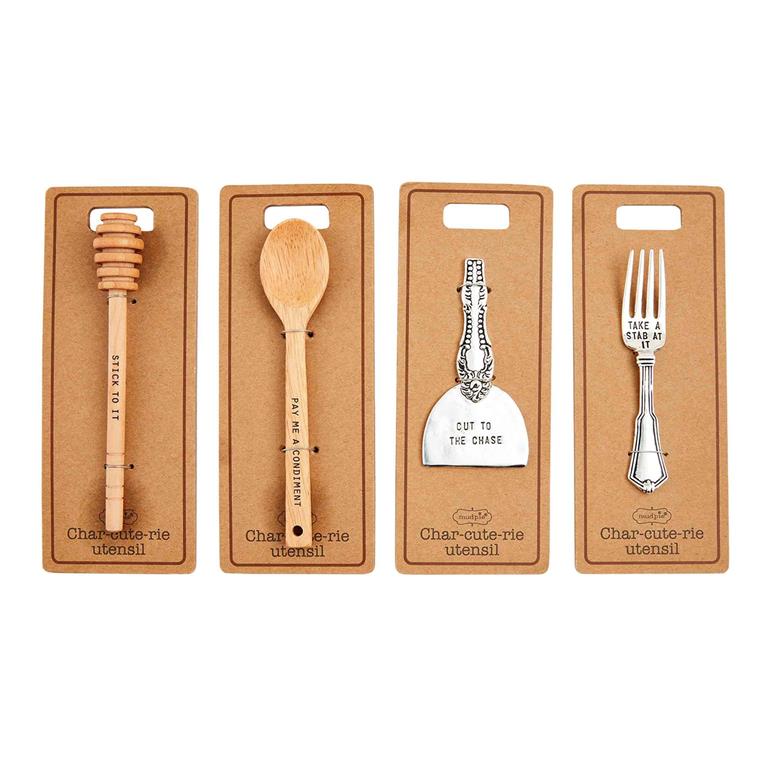 Set of charcuterie utensils including a honey dipper, wooden spoon, cheese knife, and fork on brown packaging with text.