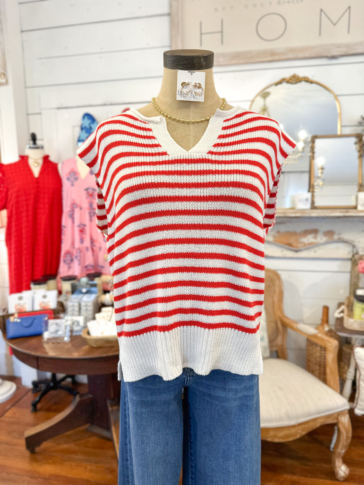 Red and white striped sweater on a mannequin in a store setting with 'HOME' sign in the background.