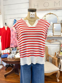 Red and white striped sweater on a mannequin in a store setting with 'HOME' sign in the background.