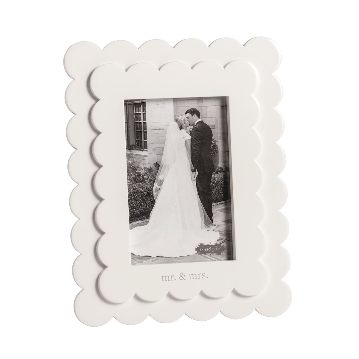White scalloped photo frame with a black and white photo of a bride and groom.