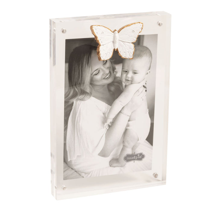 White photo frame with a black and white photo of a woman and child, and a decorative butterfly on top.