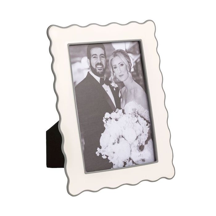 White scalloped photo frame with a black and white photo of a couple inside enamel 