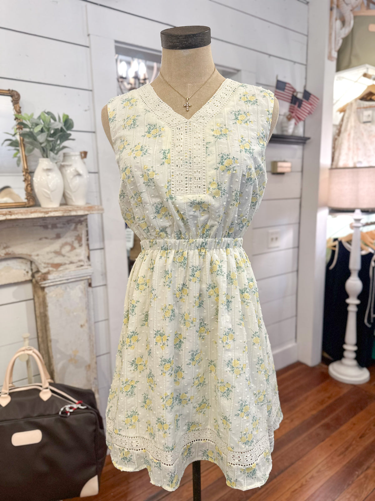 Floral dress on a mannequin in a room with decor elements.