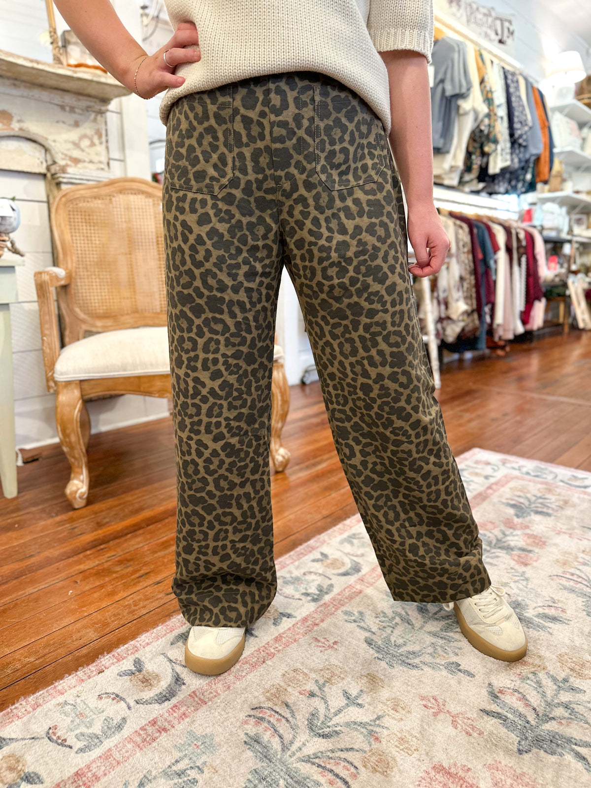 Person wearing leopard print pants in a store setting