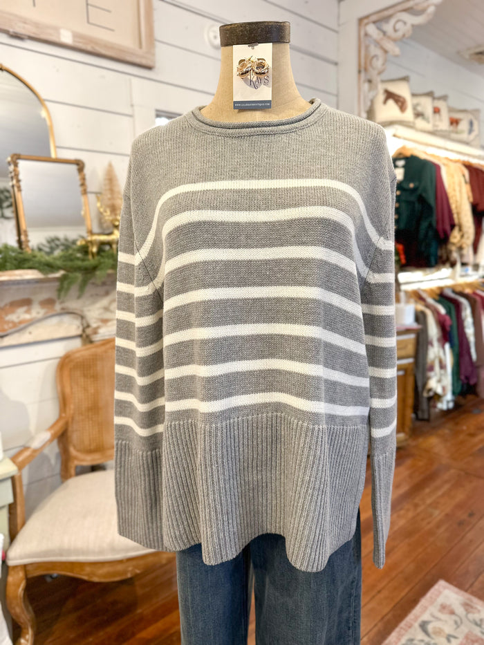 Gray and white striped sweater on a mannequin in a store setting
