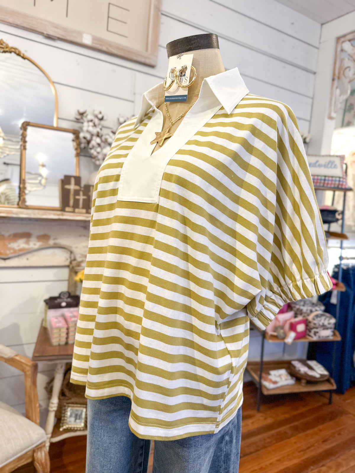 Mannequin wearing a yellow/green and white striped shirt in a store setting
