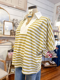 Mannequin wearing a yellow/green and white striped shirt in a store setting