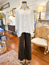 Mannequin wearing a cream linen button down  shirt and patterned pants in a store setting