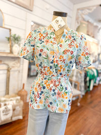 Floral blouse on a mannequin in a store setting