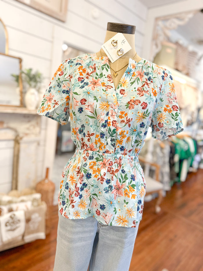 Floral blouse on a mannequin in a store setting