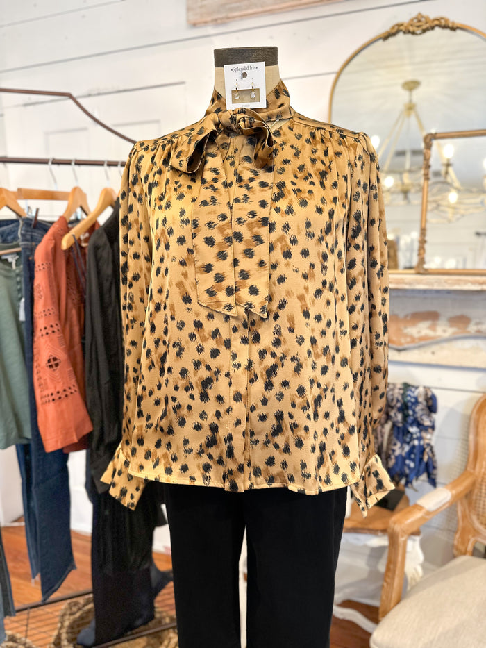 Leopard print blouse on a mannequin in a store setting with clothing racks and mirrors.