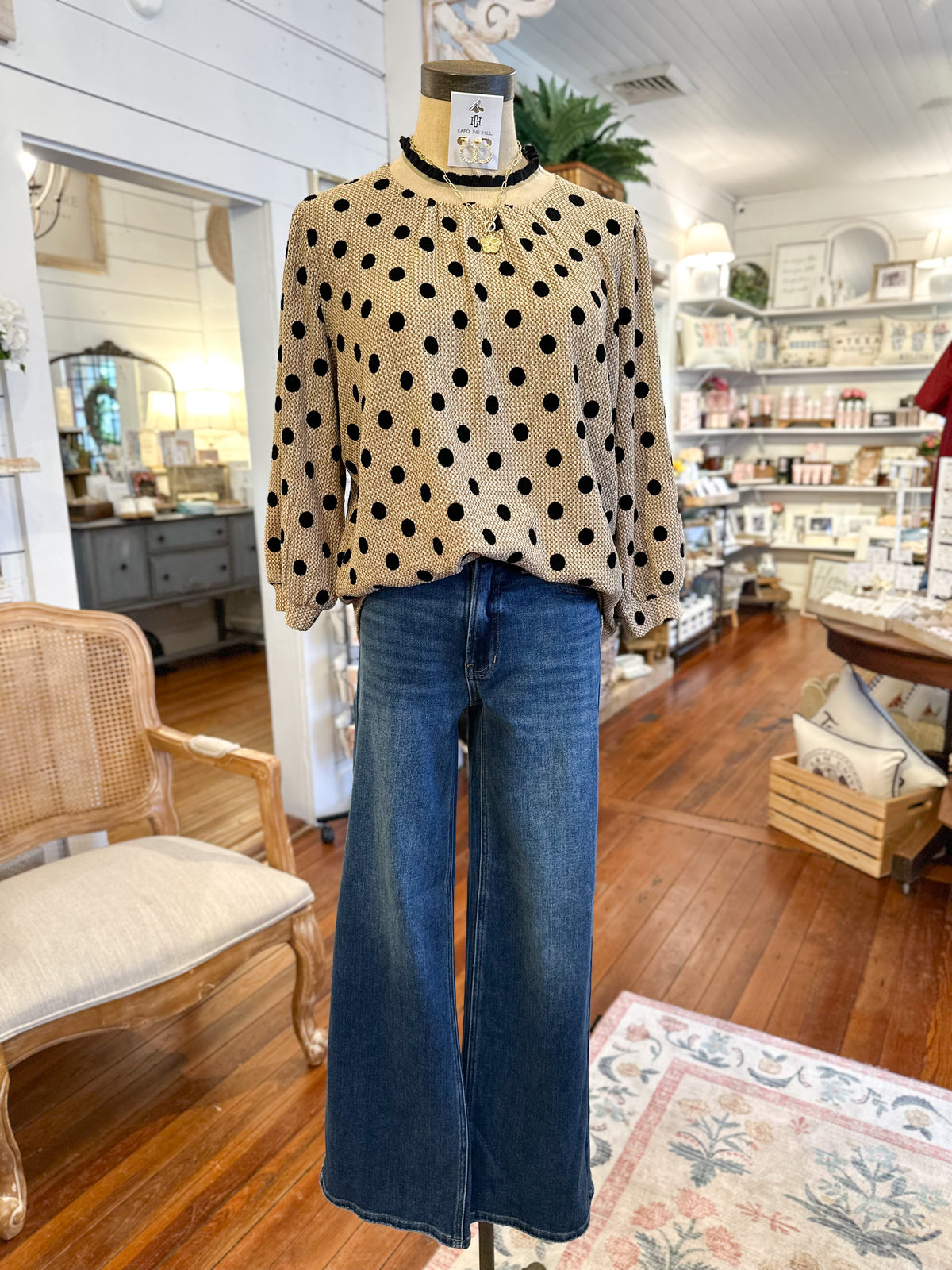 Mannequin wearing a polka dot sweater and blue jeans in a store setting