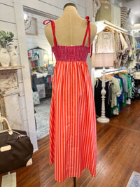 Pink and orange striped dress on a mannequin in a store setting