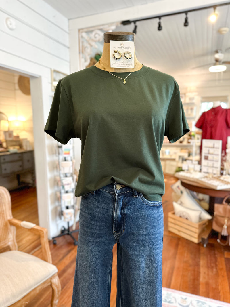 Green t-shirt and blue jeans on a mannequin in a store setting