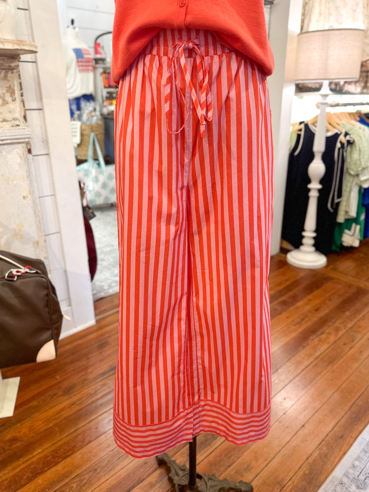 Red and orange striped pants on a mannequin in a store setting