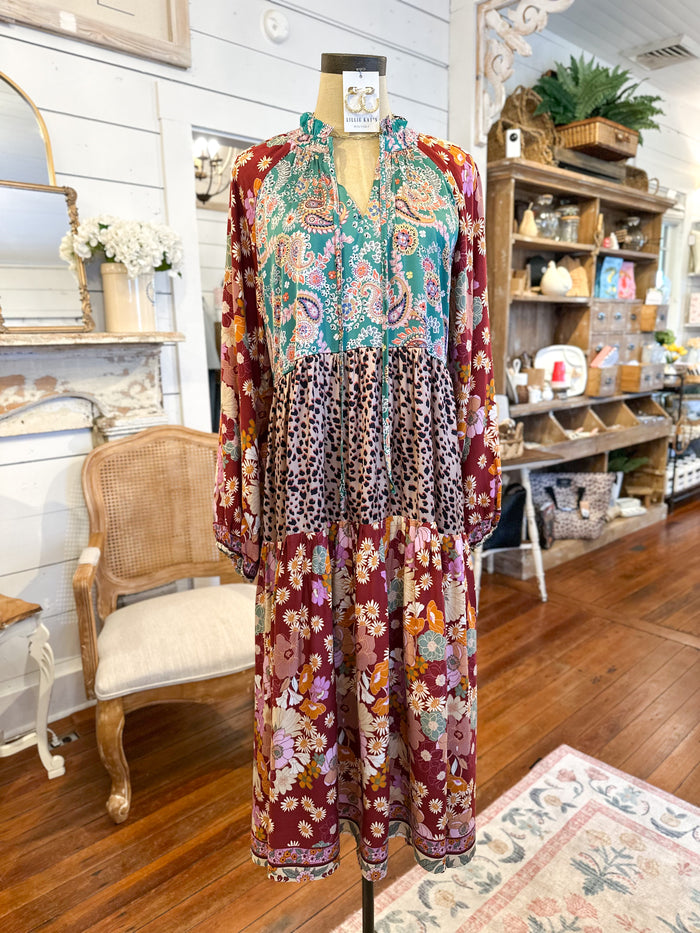 Mannequin wearing a colorful dress in a store setting with shelves and decor. umgee maxi dress