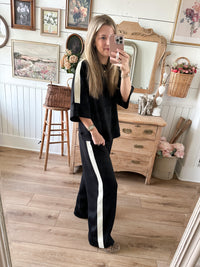 side view of loungewear set in black with cream contrast stitching on the side 
