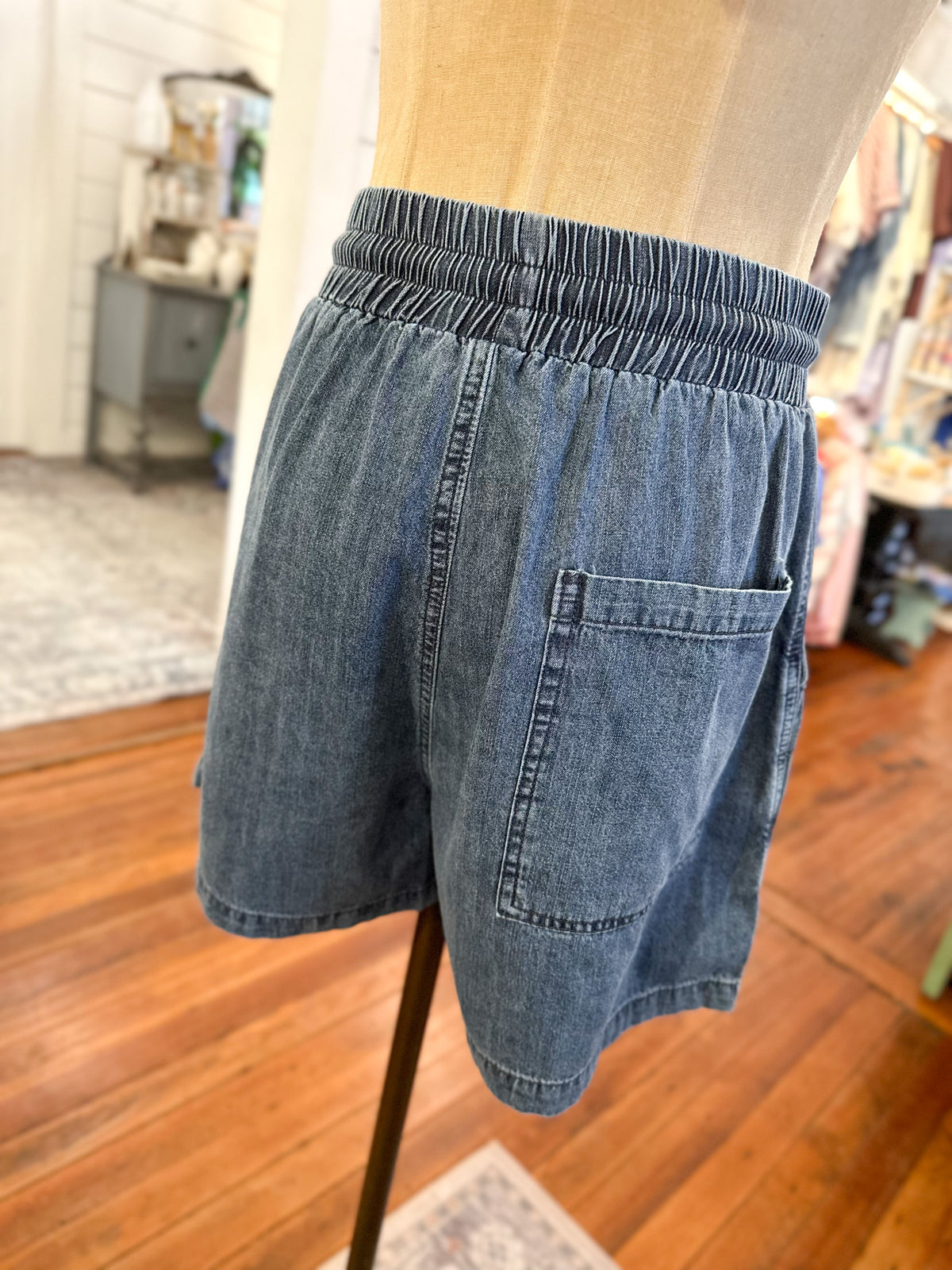 Blue denim shorts on a mannequin against a blurred indoor background