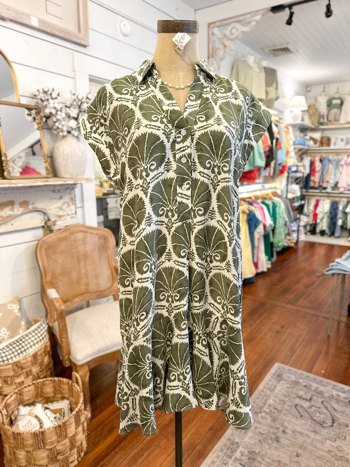 Green patterned dress on a mannequin in a store setting