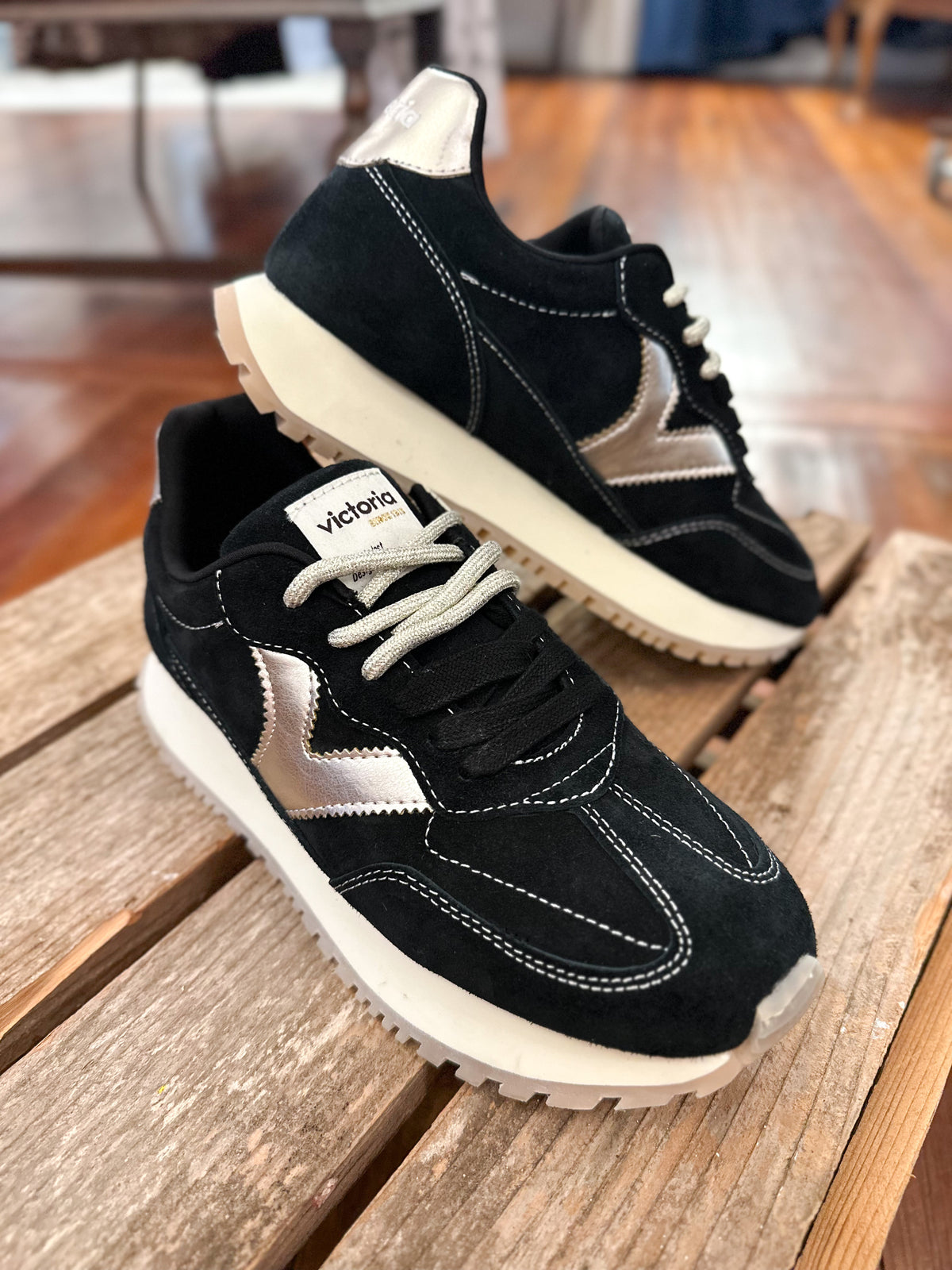 black Victoria sneaker with metallic V on the side inside the store 