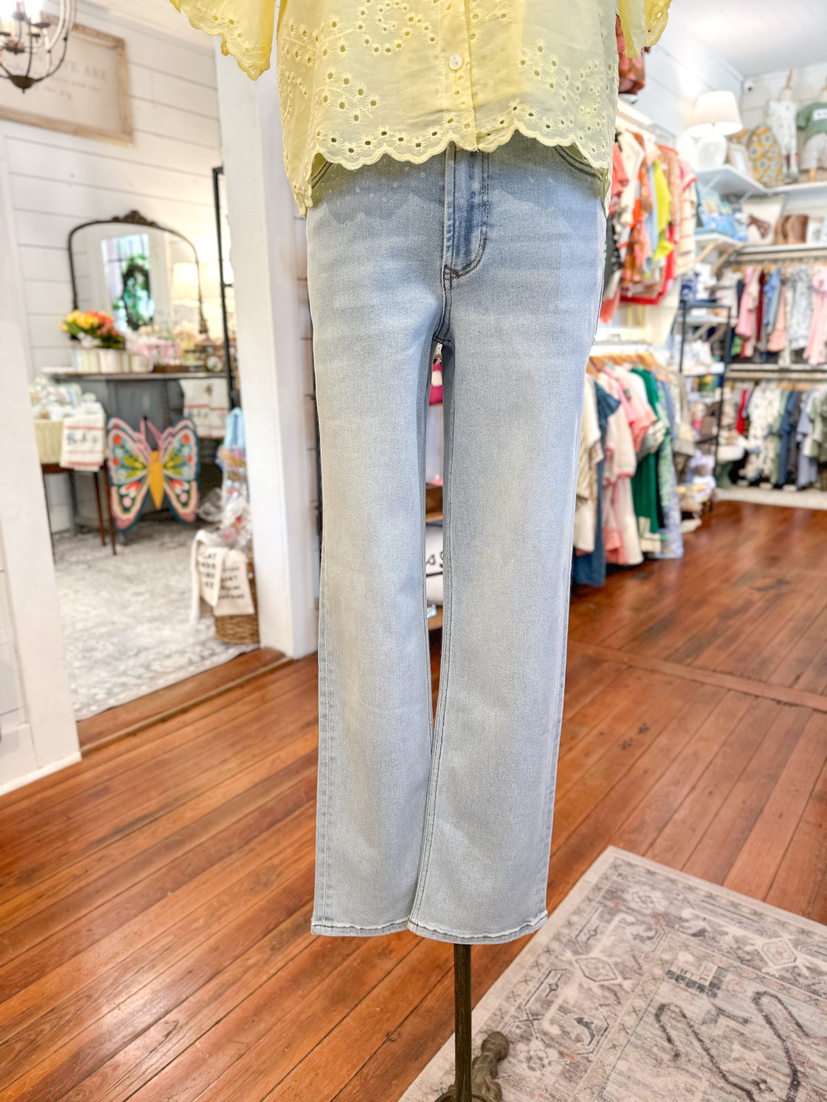 Mannequin wearing light blue jeans and a yellow top in a store setting