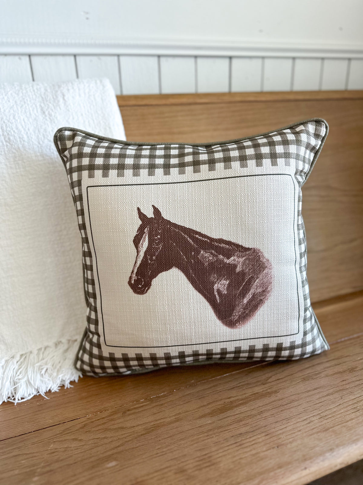 Decorative pillow with horse design on a wooden surface