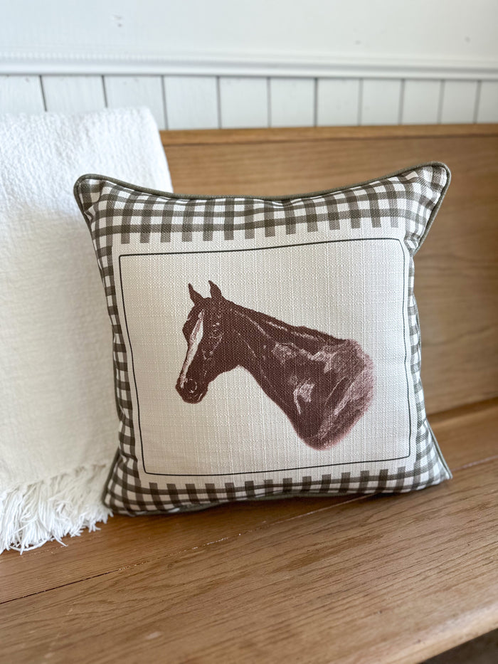 Decorative pillow with horse design on a wooden surface