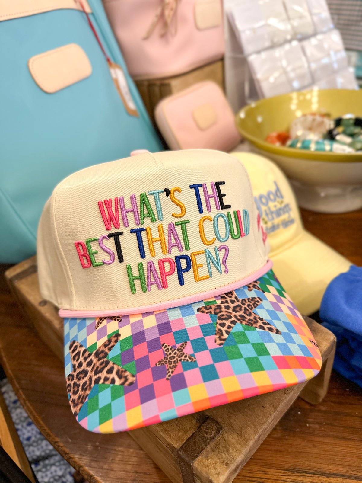 Colorful cap with text and pattern on a wooden surface What's the best that could happen 