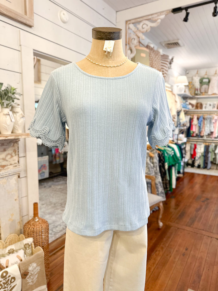 Light blue blouse on a mannequin in a store setting