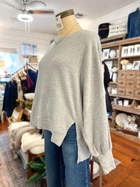 side view of grey long sleeve pullover top 
in side store 