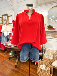 bright red 3 quarter sleeve blouse with ruffle details around the collar 