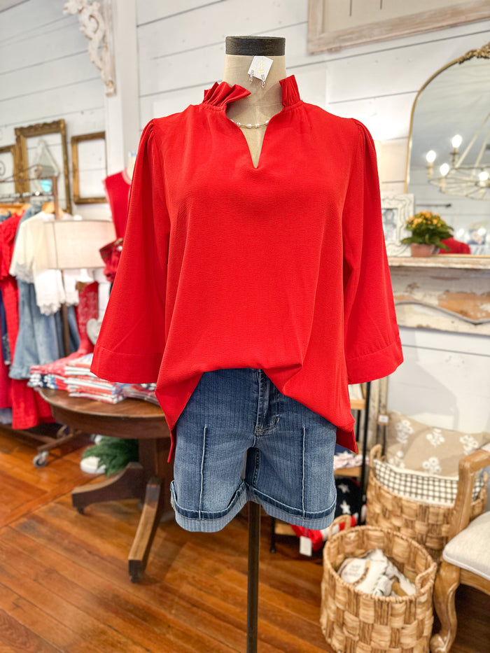 bright red 3 quarter sleeve blouse with ruffle details around the collar 