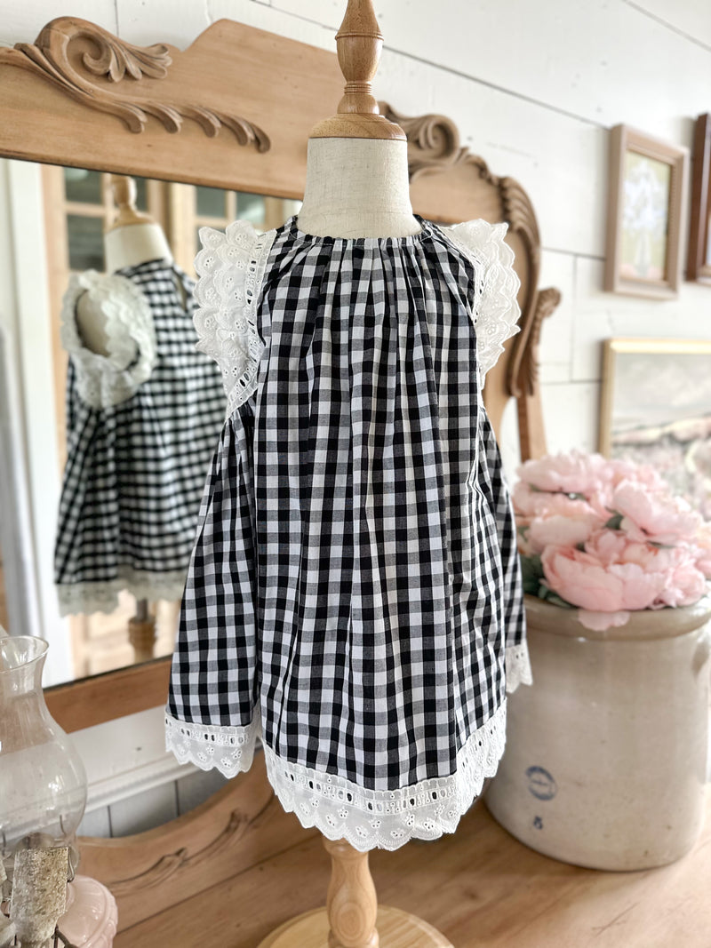 Black and white checkered dress with lace trim on a mannequin against a decorative background. toddler youth sizes 