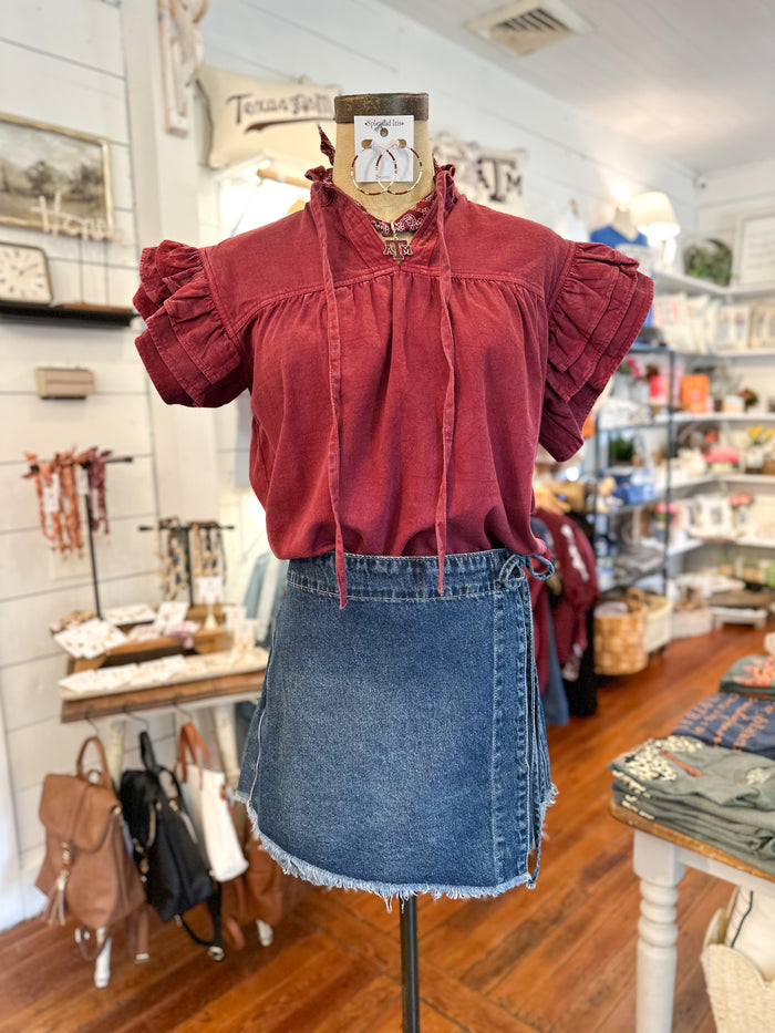 Mannequin wearing a red blouse and blue denim skirt in a store setting