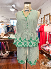 Green and white striped outfit on a mannequin in a store setting