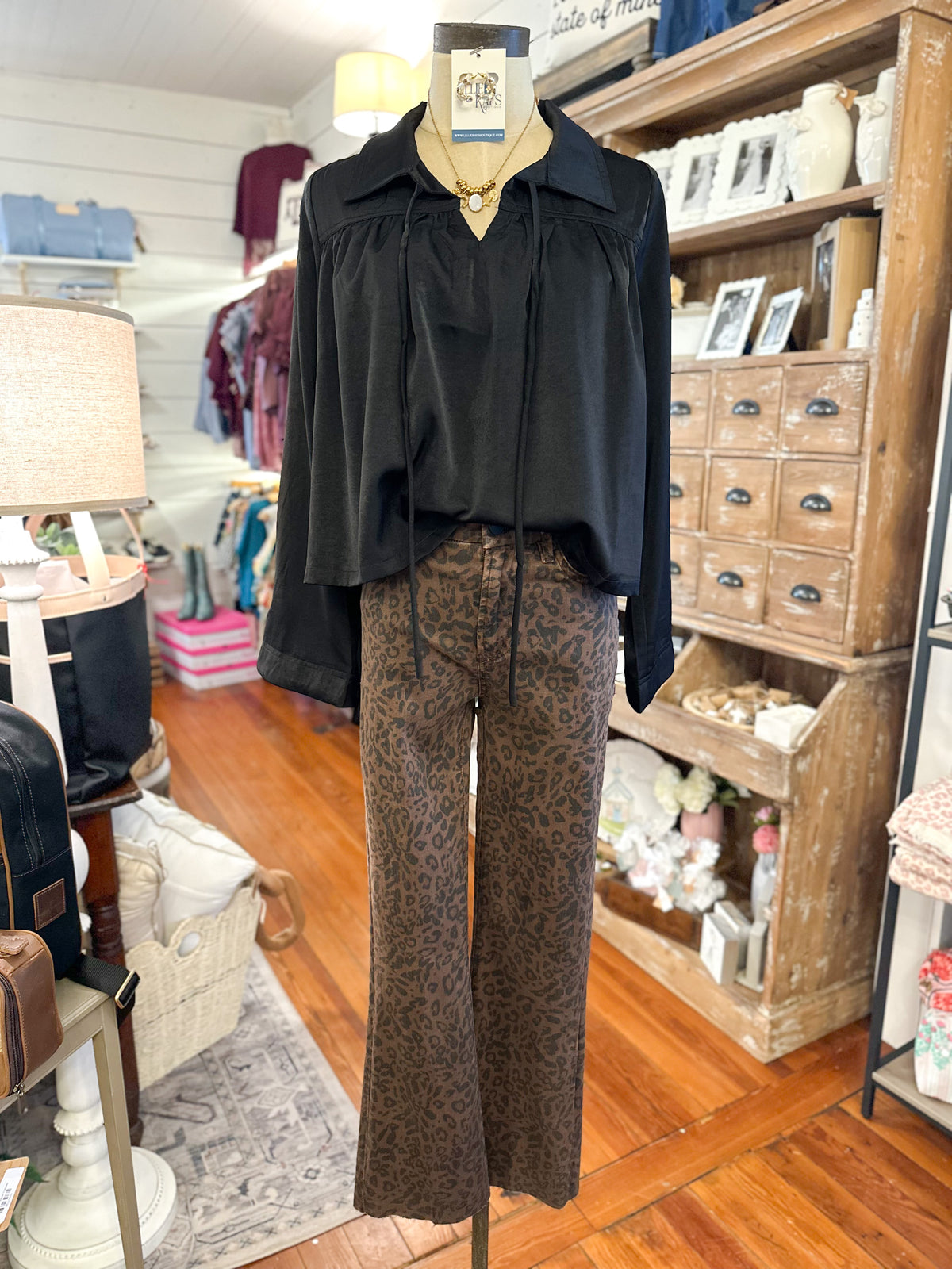 black long sleeve top paired with brown and black printed jeans inside boutiques store 
