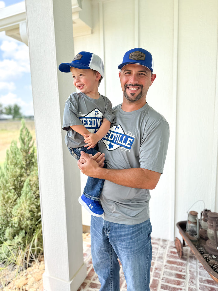 Man holding a child on a porch with a scenic background