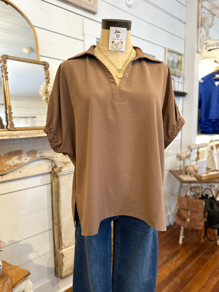 Brown shirt on a mannequin with a tag in a store setting