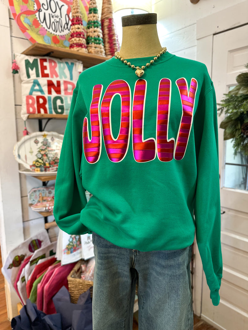 Green sweatshirt with colorful 'JOLLY' text on a mannequin in a store setting.