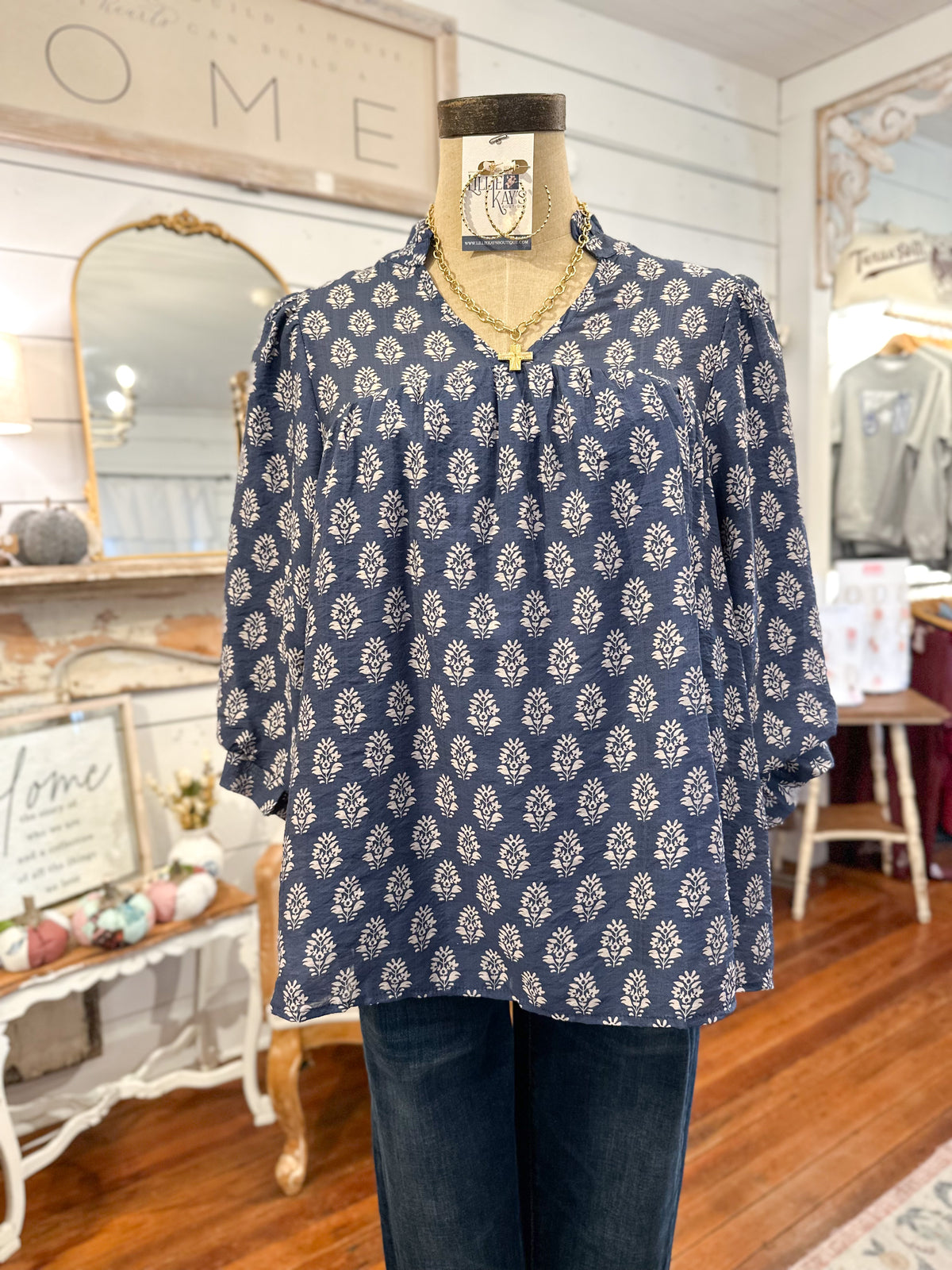 Blue patterned blouse on a mannequin in a store setting