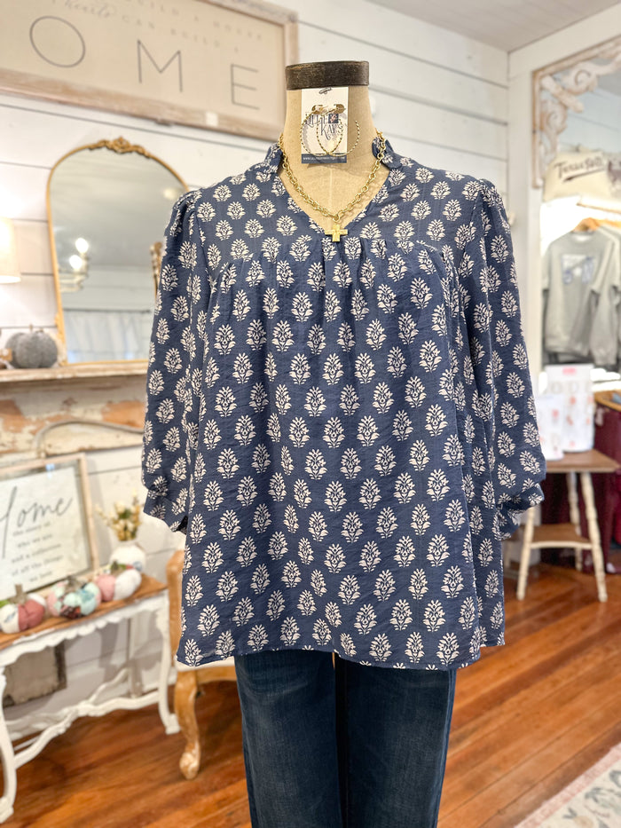Blue patterned blouse on a mannequin in a store setting